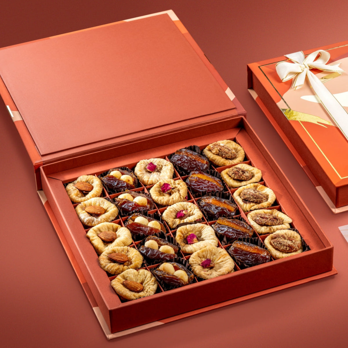 Open Opulent gift box with assorted figs, stuffed dates, nuts, and dried fruit, beautifully arranged in compartments.