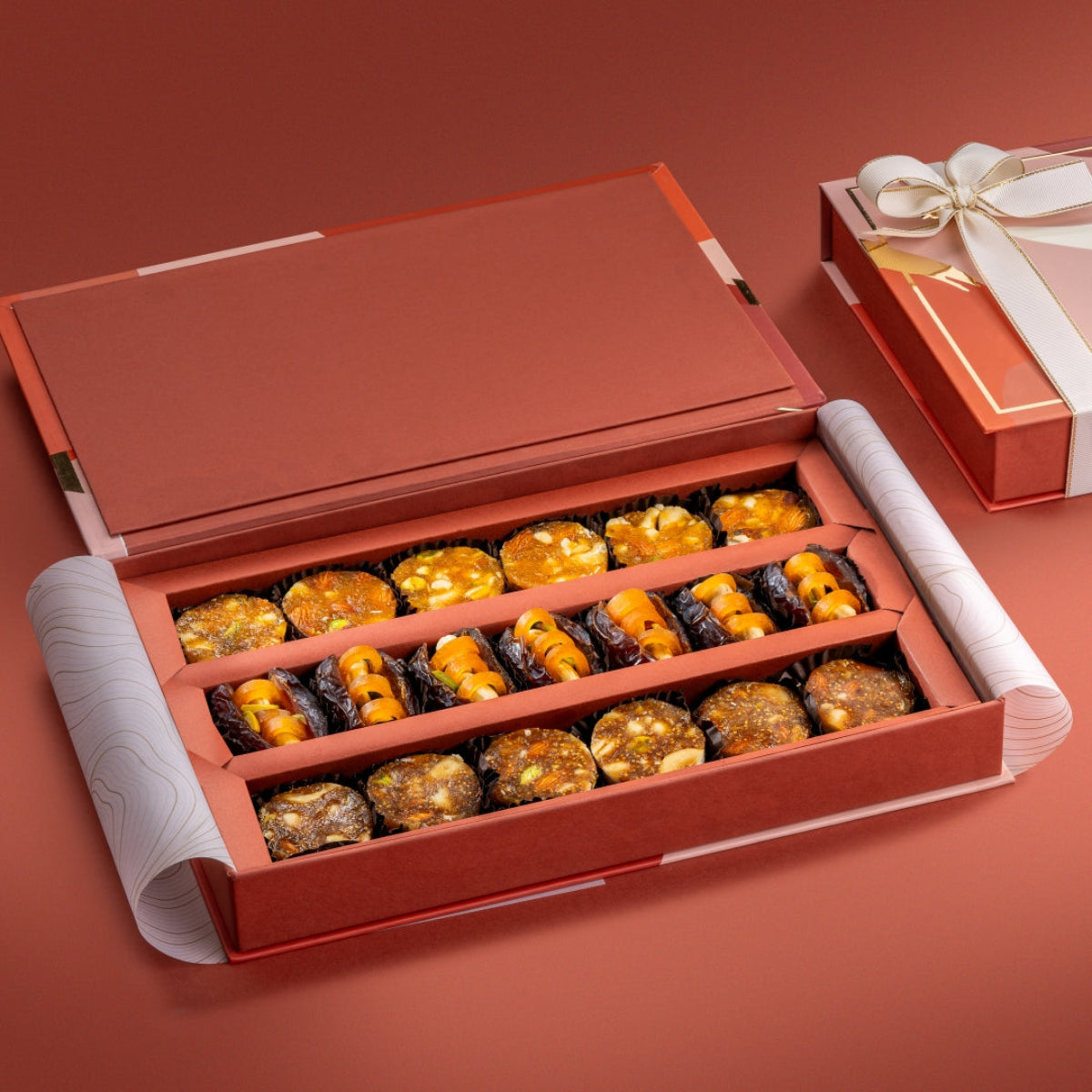 Open Regal Assorted Box showing fig & nut bites, mejdool dates stuffed with cashews and dried mango, and apricot nut bites.