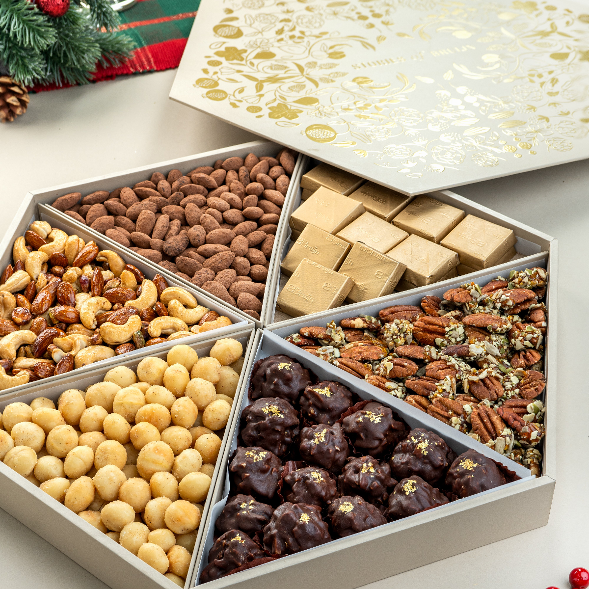 An assorted tray of Christmas-themed candies and chocolates, featuring a variety of shapes and flavors, displayed against a festive background with Christmas decorations.