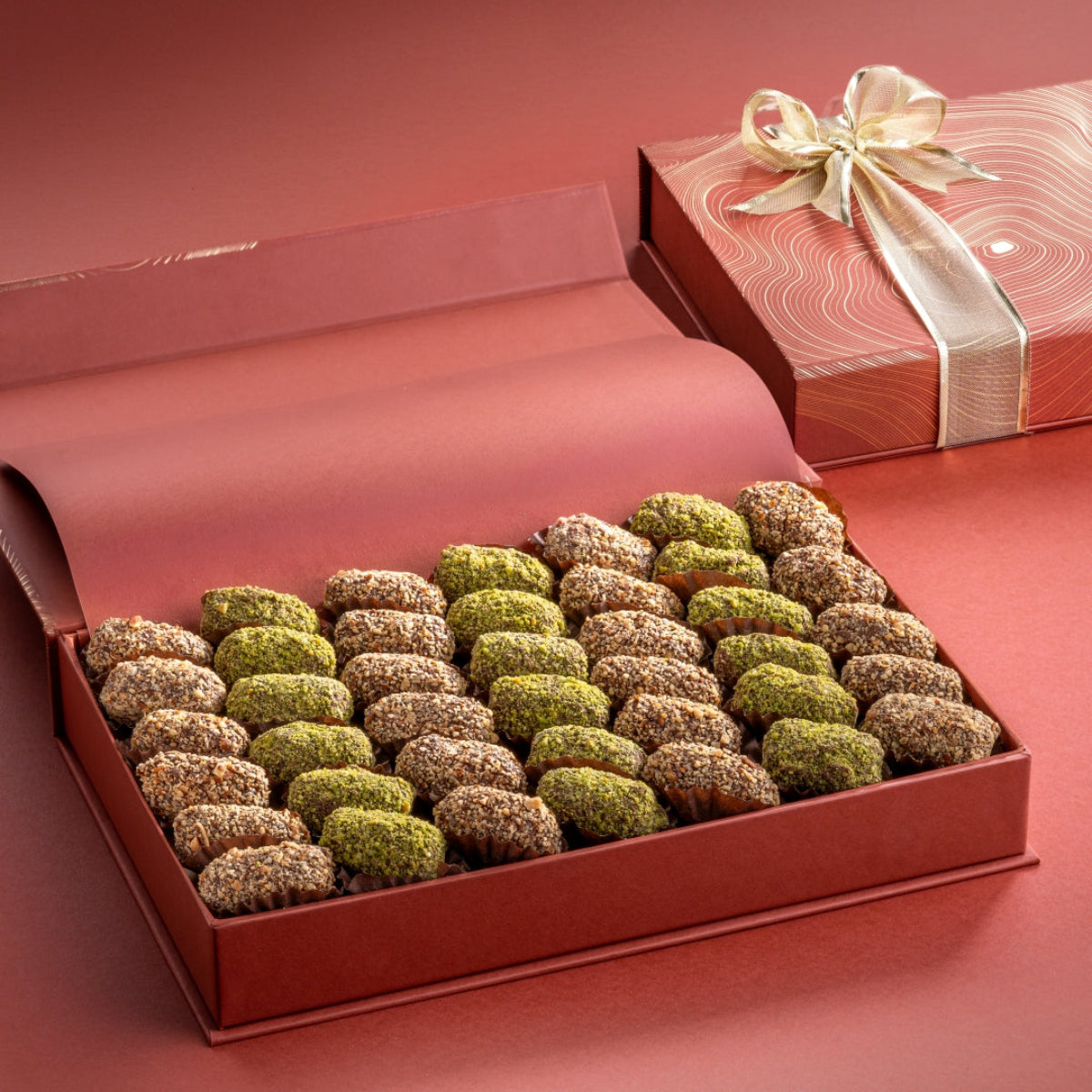Open rust gift box with date truffles encrusted in diced nuts, flavored with saffron, cardamom and orange blossom water.