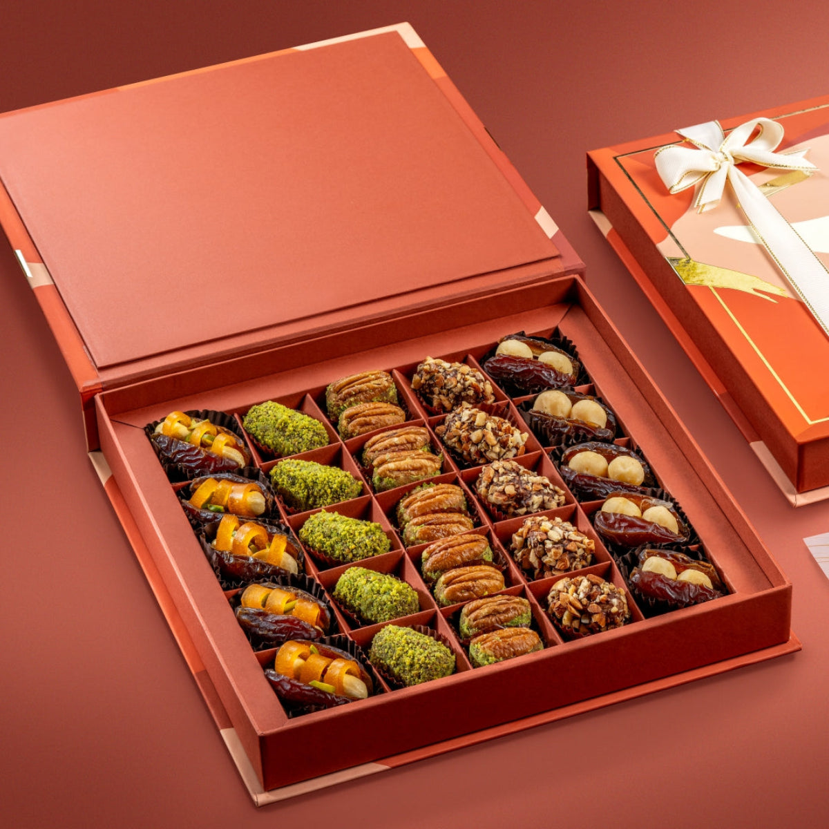 Open box of Bruijn Opulent Dates Collection showing stuffed Mejdool dates, truffles, pecan wholes, and macadamia-stuffed dates.