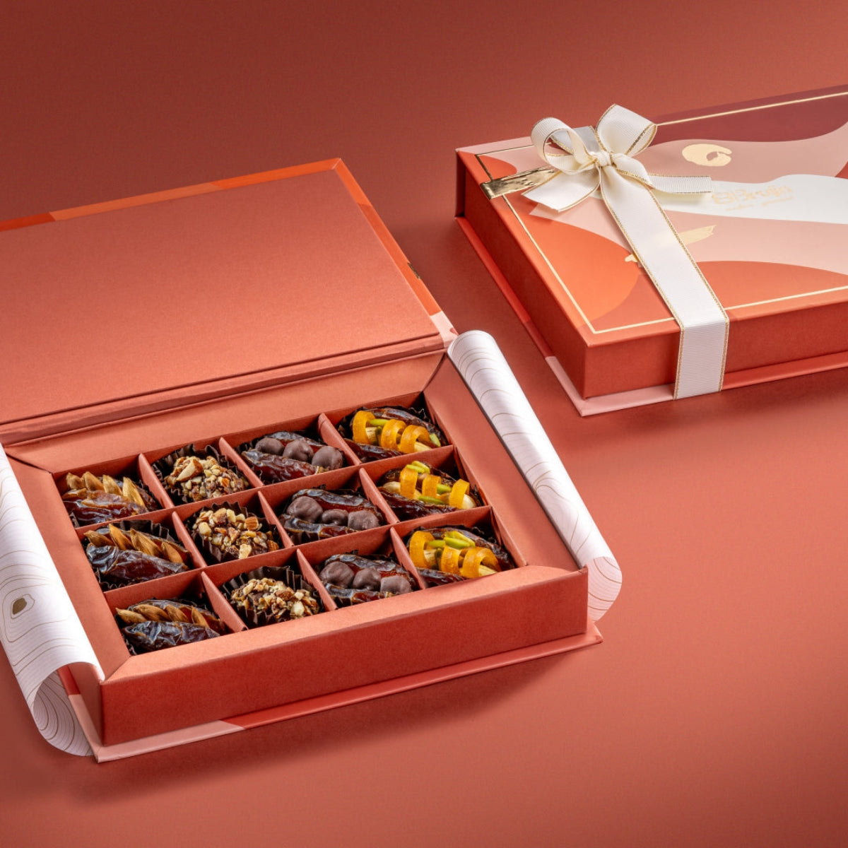Open Healthy Dates Dual Box with ribboned lid, showcasing an assortment of stuffed Mejdool dates and truffles with nuts, chocolate, and dried mango.