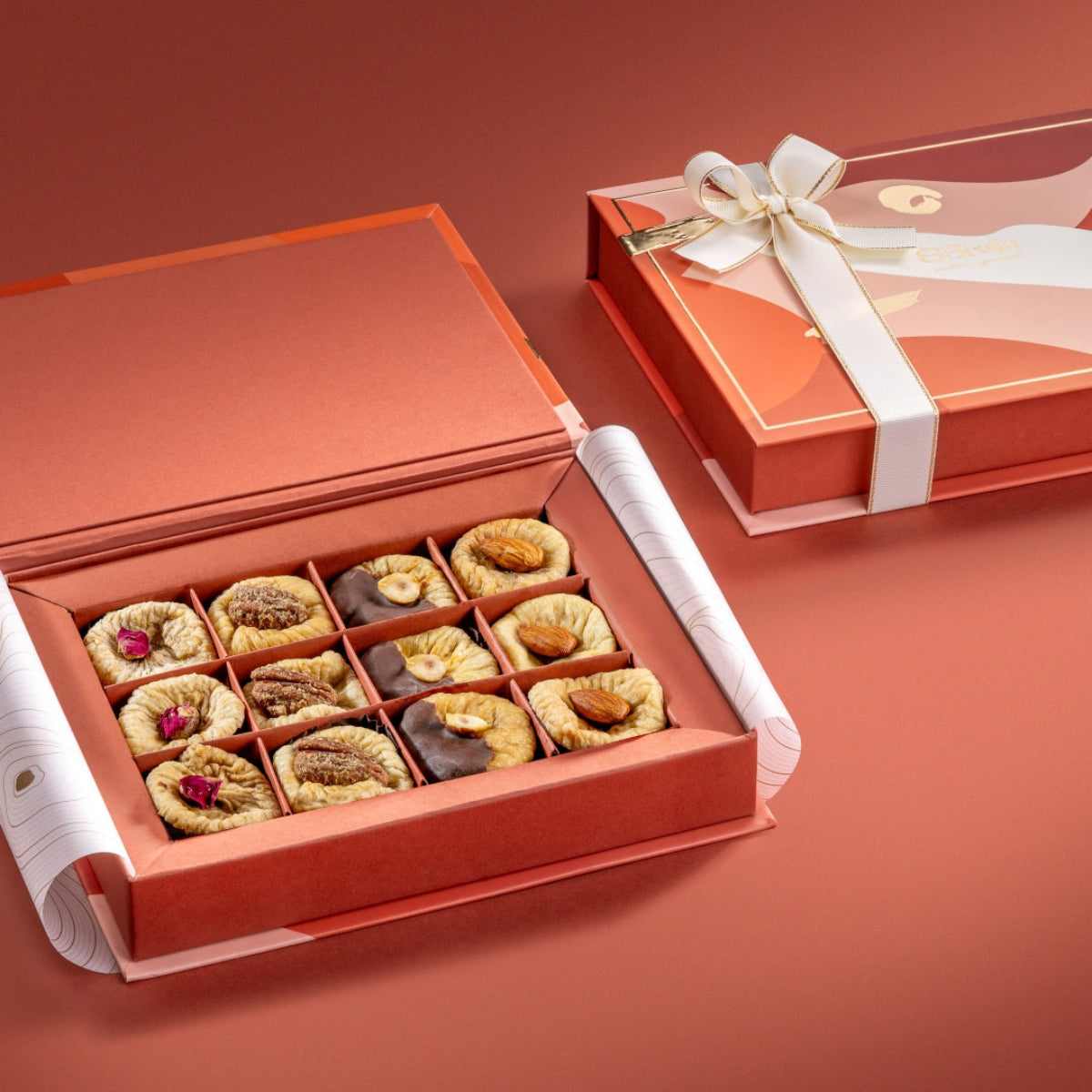 Bruijn Dual Box showing assorted fig delights including saffron pistachio & rose figs, ginger pecan figs, chocolate hazelnut figs, and almonds with orange peel, neatly arranged in compartments.