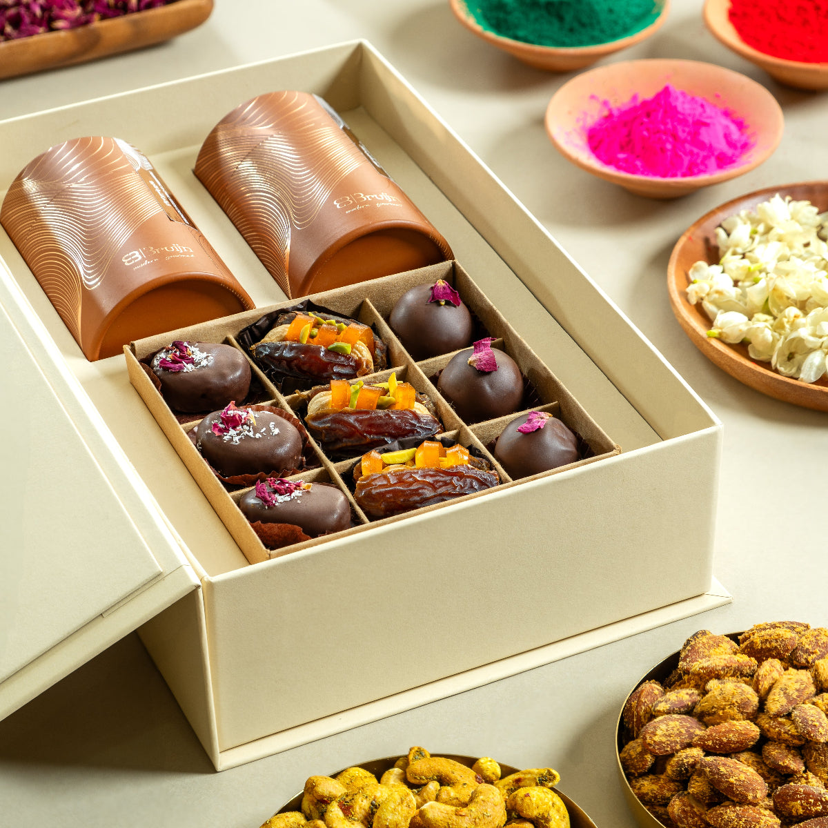 A box of assorted gourmet snacks including nuts, chocolates, and other confectionery treats displayed on a table.