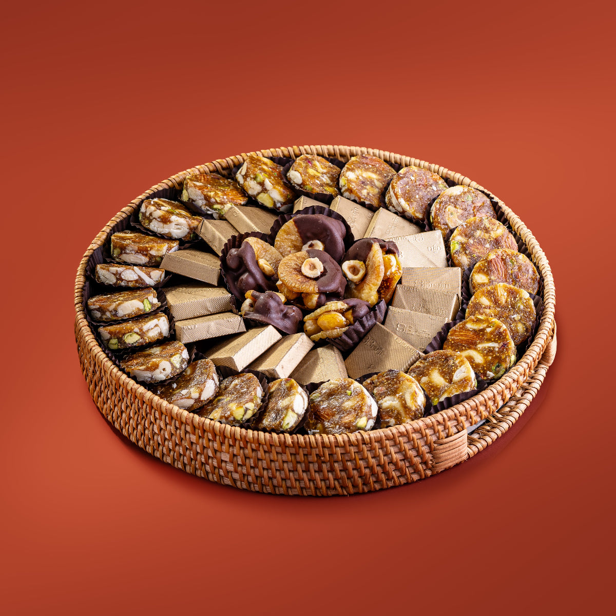 Round eco-friendly tray filled with 1kg of artisanal fig and nut bites alongside pure cacao dark chocolate with nuts, beautifully arranged for gifting.