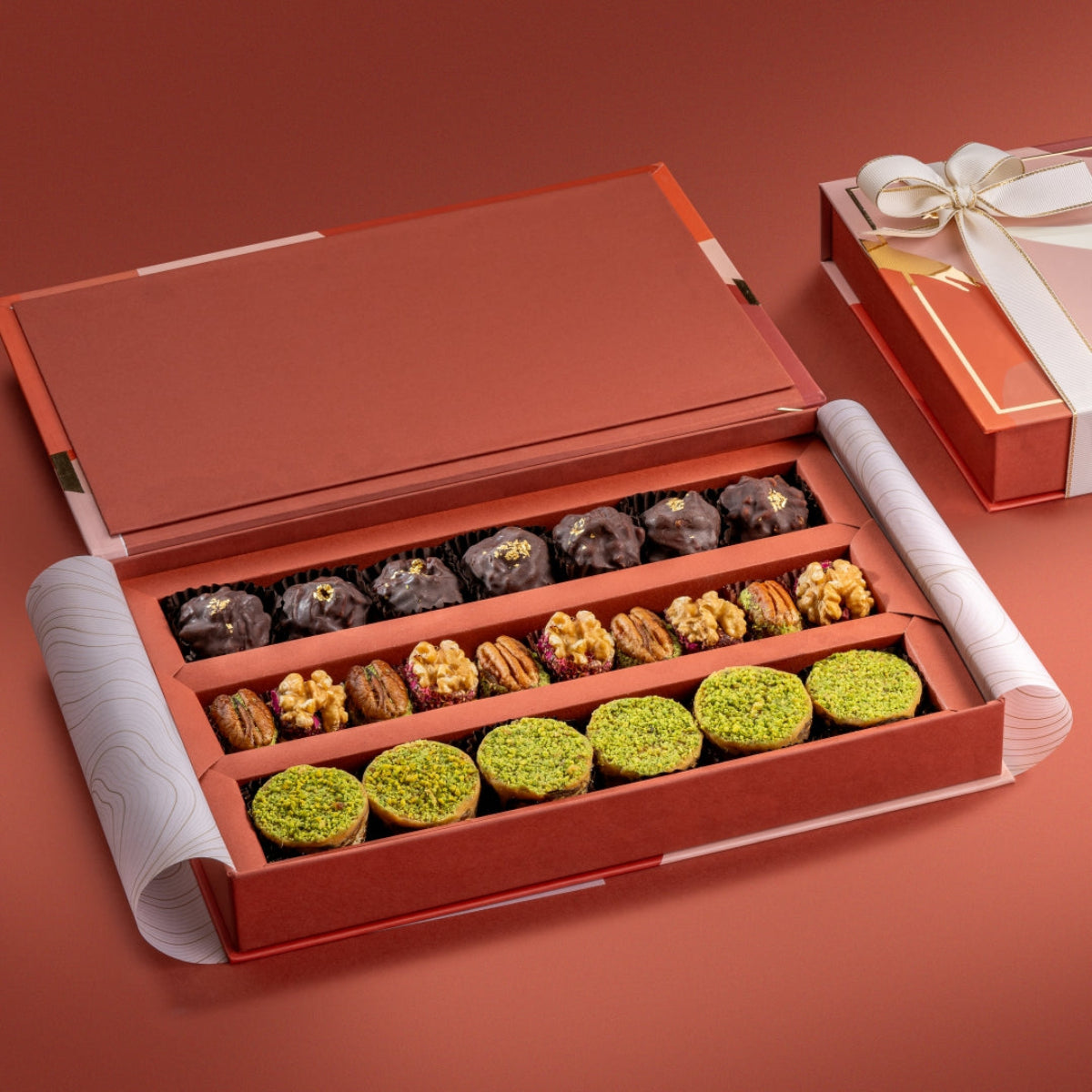 Open festive Bruijn Medley Collection box with almond rocks, pecan & walnut wholes, and ranginak arranged in rows.