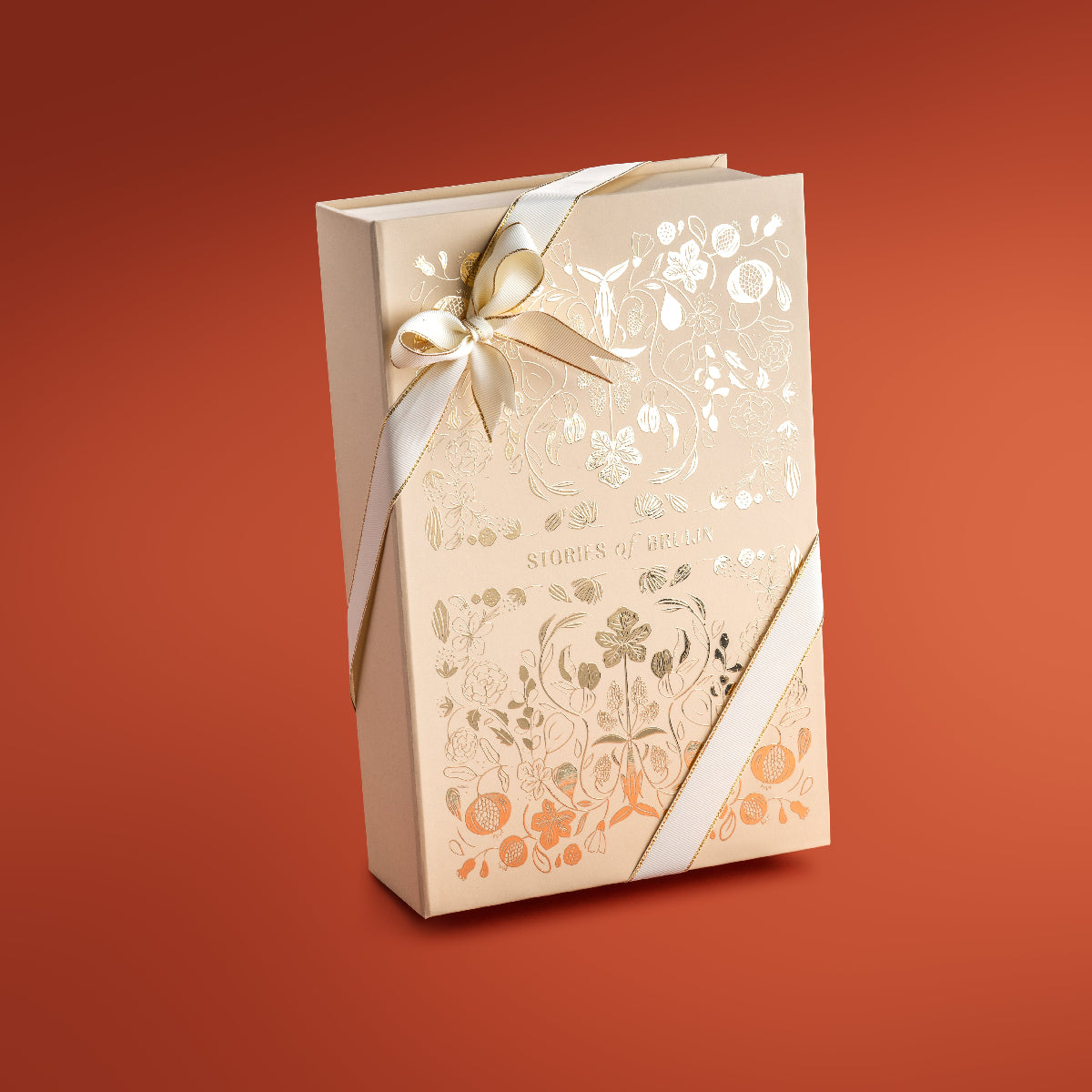 Closed cream Stories of Bruijn Grand Box with gold floral pattern and white ribbon.