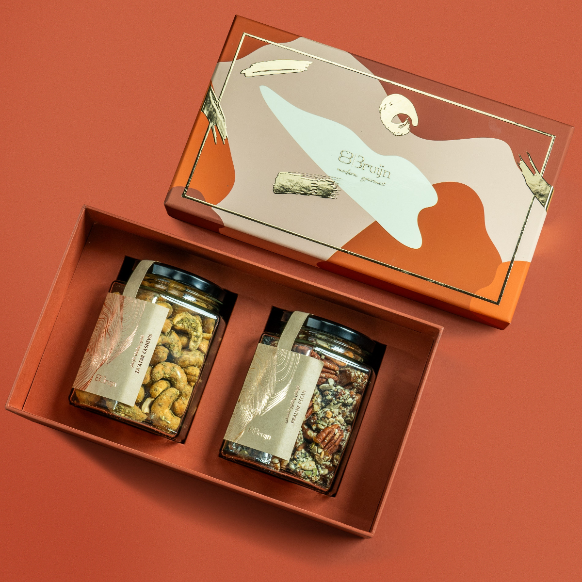 Modern Abundance Box (Brown) in Bruijn Edition with artistic patterned lid, containing two glass jars — one of Za’atar Cashews and one of Praline Pecans — nestled in a premium gift tray.