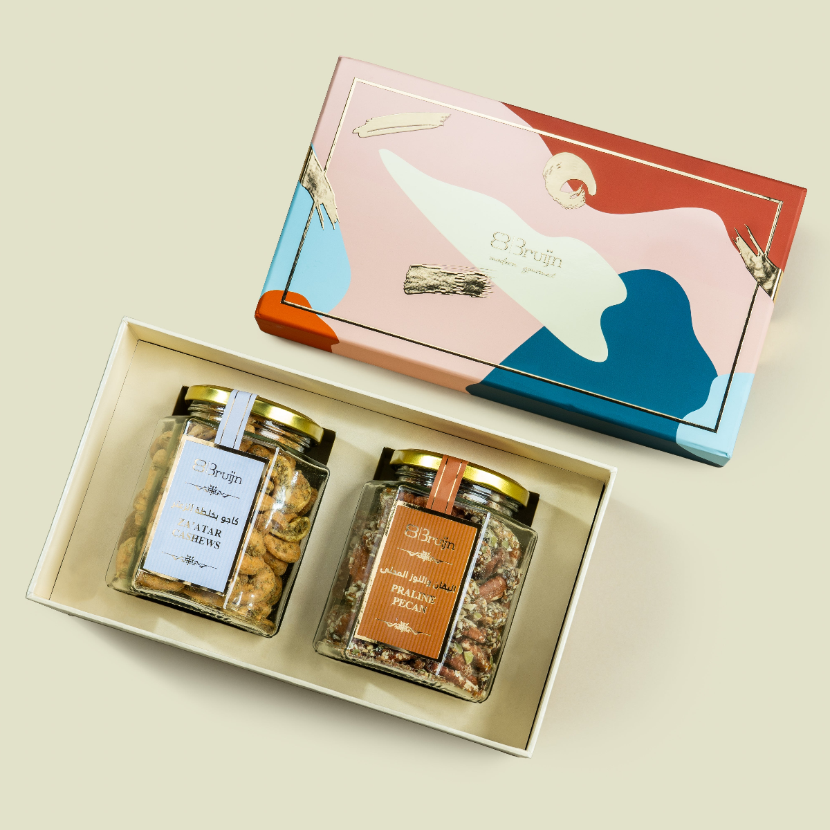 Modern Abundance Box (Pastel) in Bruijn Edition with artistic patterned lid, containing two glass jars — one of Za’atar Cashews and one of Praline Pecans — nestled in a premium gift tray.