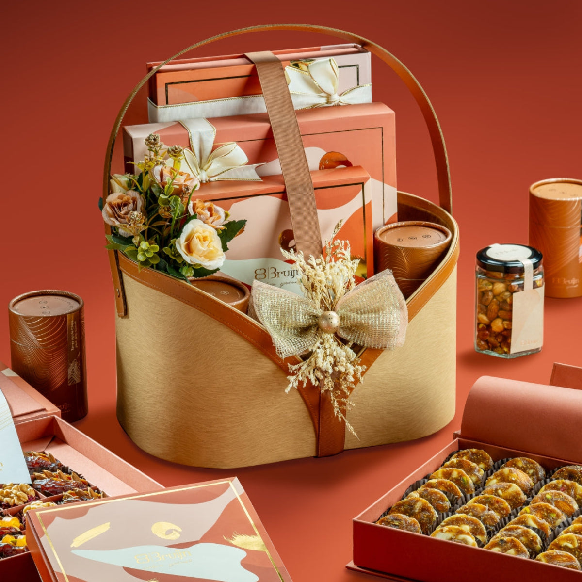 Motley Basket gift hamper with rust box of fig & apricot nut bites, candid box of dates and figs, petite ranginak box, nut jars, and apple chips.