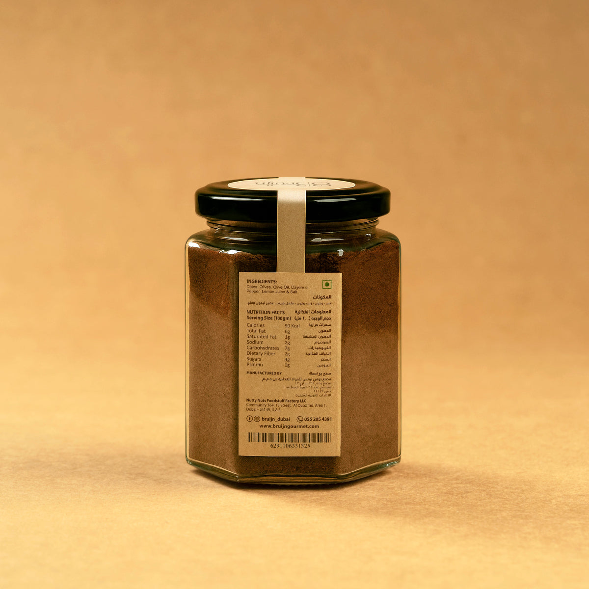Glass jar of Bruijn Olive & Date Tapenade with black lid and kraft label, containing a dark, rich spread made from sun-dried black olives and dates.