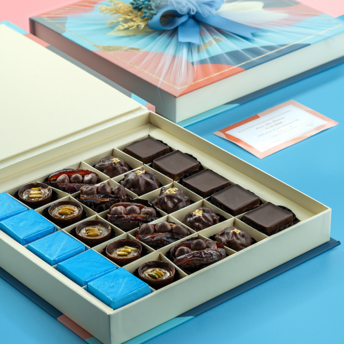Opulent Chocolate Collection box with blue-wrapped cover and assorted chocolates, figs, dates, and almond rocks.