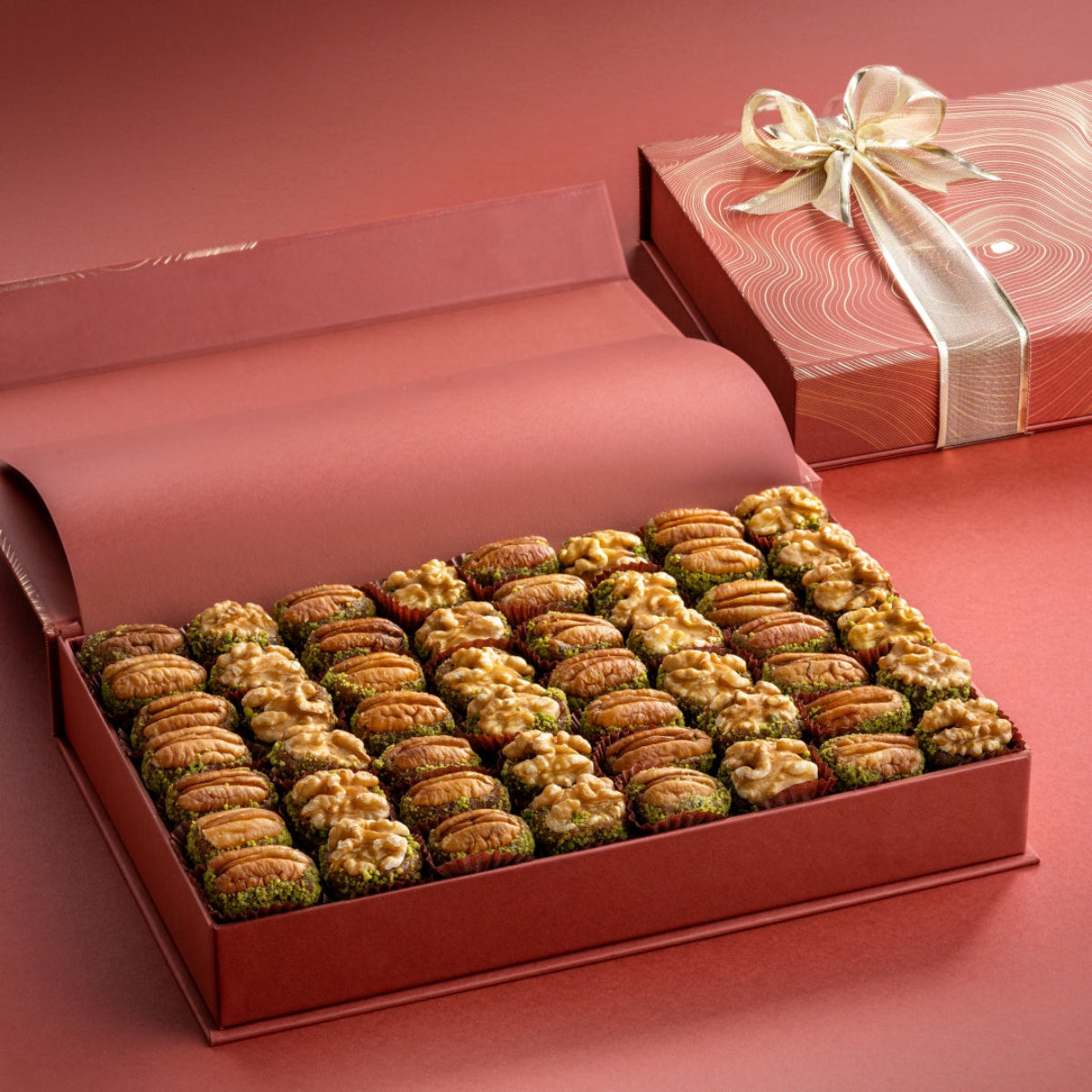 Open rust box with 52 pecans and walnuts stuffed with pure dates and pistachio, elegantly packed for gifting and indulgence.