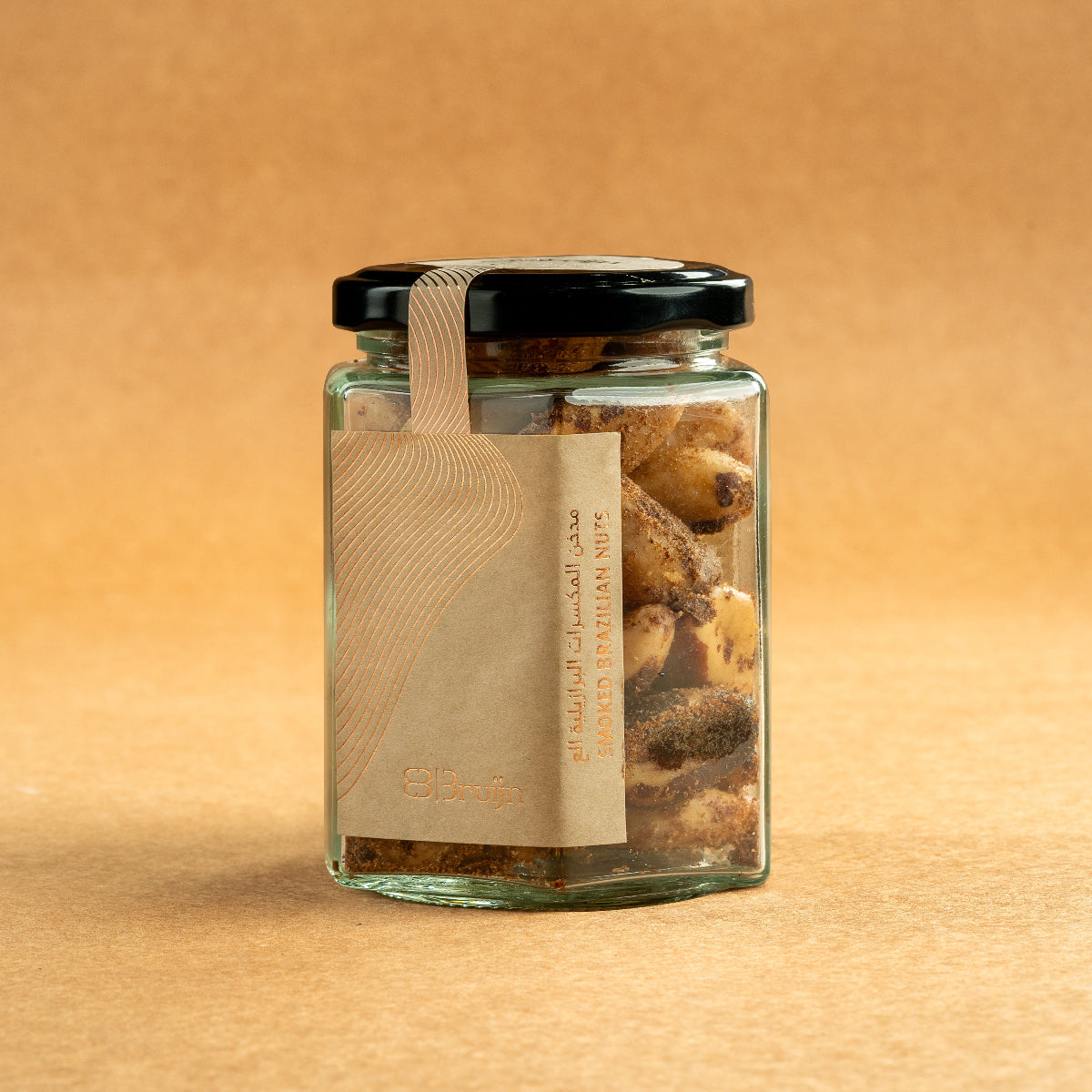 Glass jar of Bruijn Hickory Smoked Brazil Nuts with black lid and kraft label, filled with large Brazil nuts infused with smoky hickory flavour.