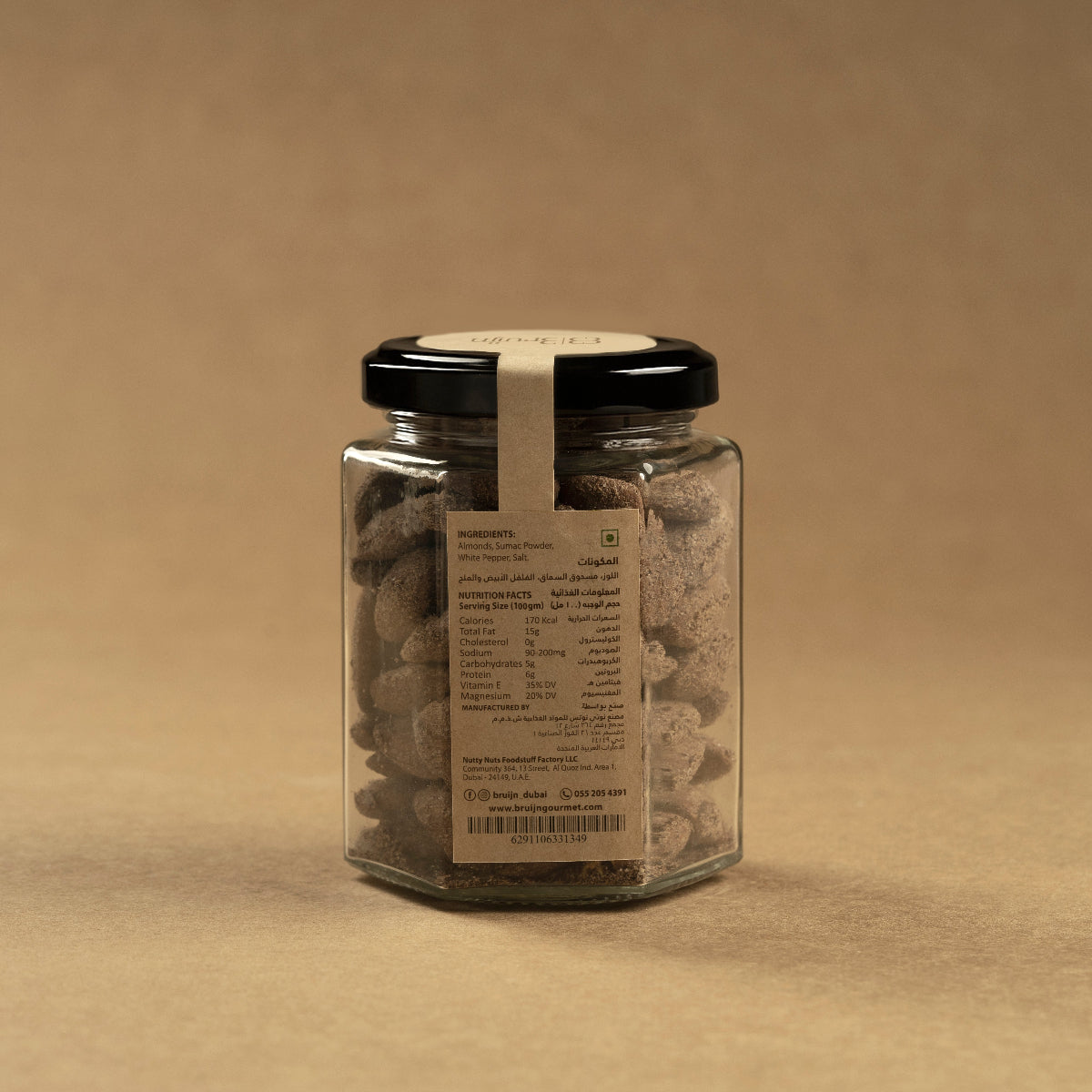 Glass jar of Bruijn Sumac & White Pepper Almonds with black lid and kraft label, filled with roasted almonds coated in a citrusy sumac and pepper seasoning.