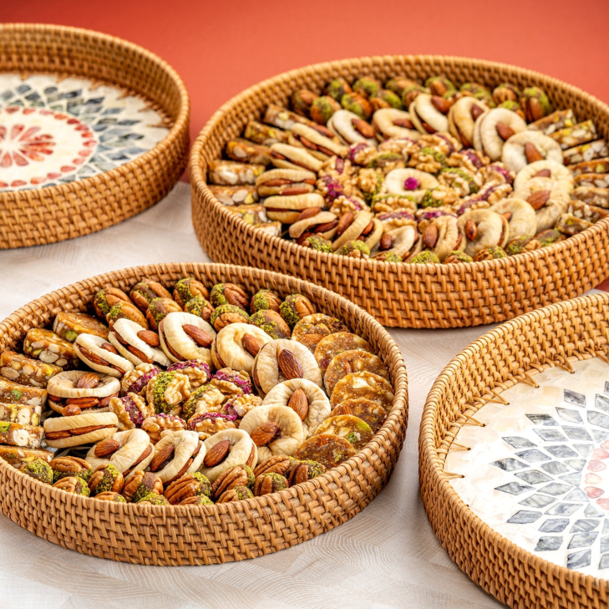Round sustainable tray with figs, dates, and assorted nut-filled delights arranged in a circular pattern.