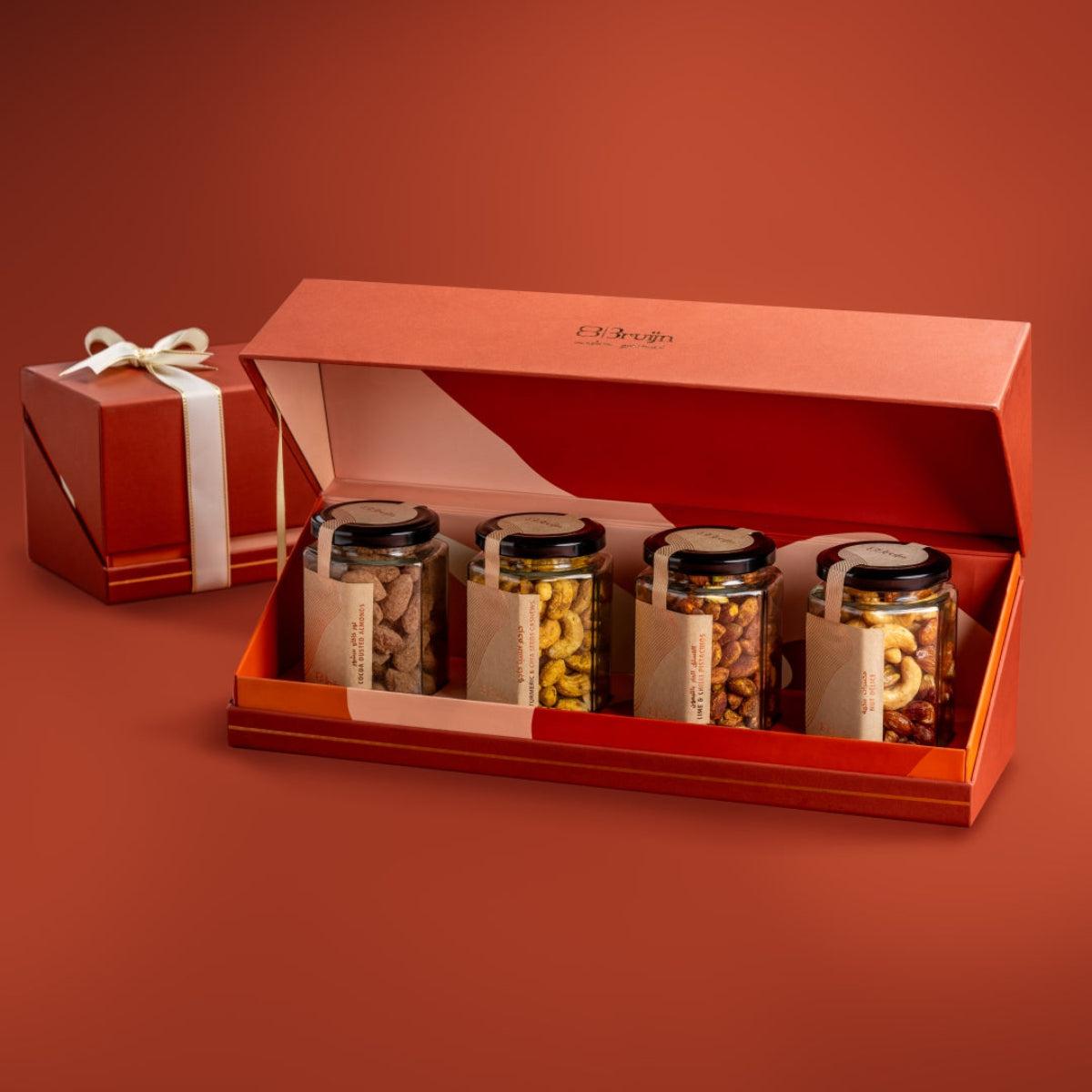 Open Bruijn festive jar box with Cocoa Dusted Almonds, Turmeric & Chia Cashew, Lime & Chilli Pistachio, and Salted Caramel Nut DΓ©lice jars.
