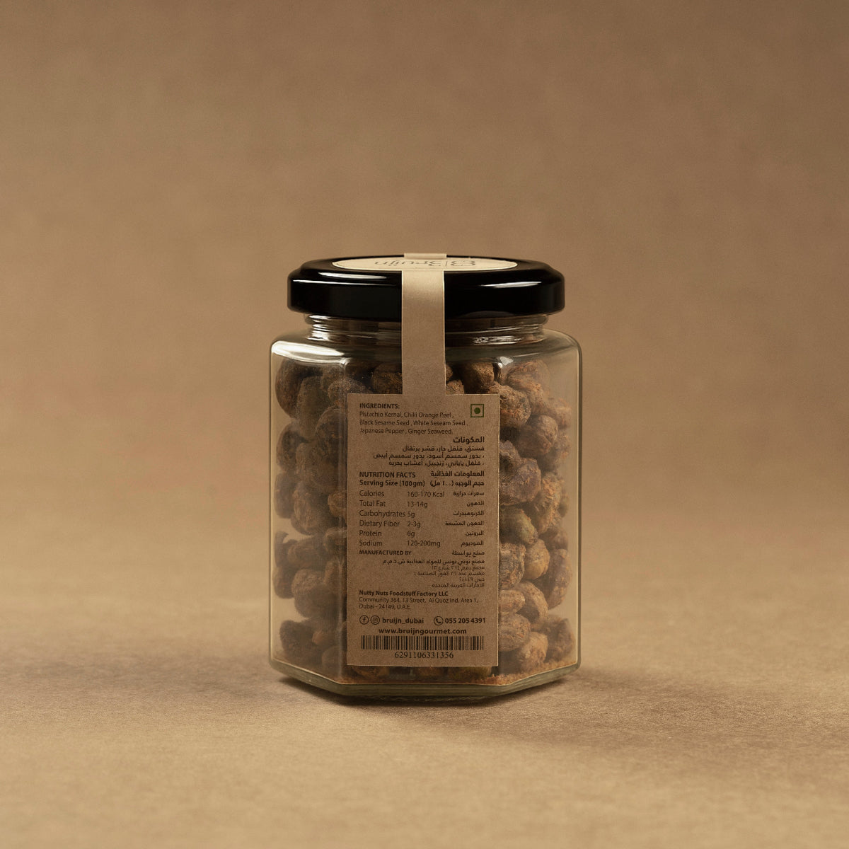 Side view of Bruijn Shichimi Togarashi Pistachios jar against a neutral background, showcasing the spiced pistachios through the glass.