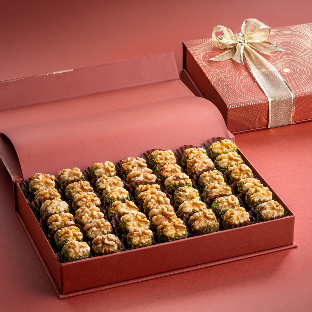 Luxury rust-toned gift box with 63 Chilean walnuts stuffed with dates & pistachio, neatly arranged in rows.