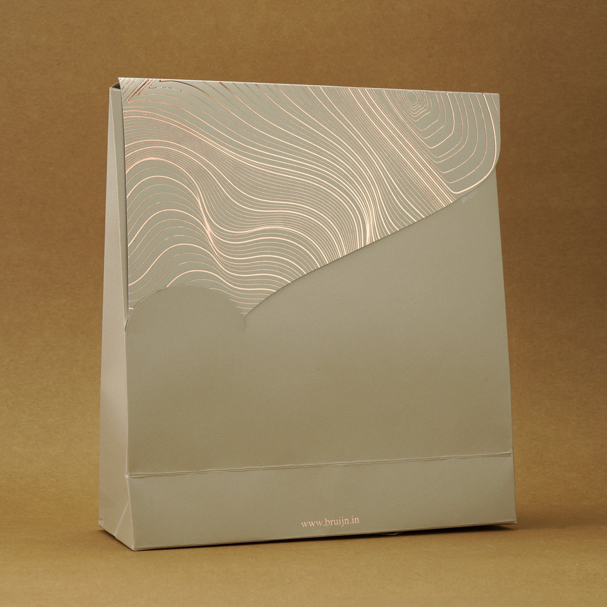 Sustainable gift bag with biodegradable cylinders holding apple chips, black truffle peanuts, and salted caramel nut mix.