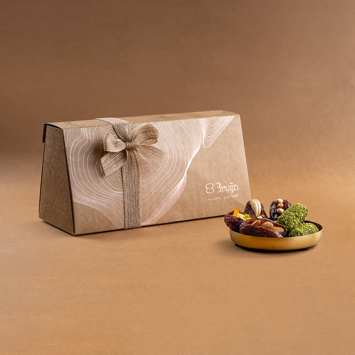 Large gift pack wrapped in textured beige paper with ribbon, containing assorted Medjool dates.