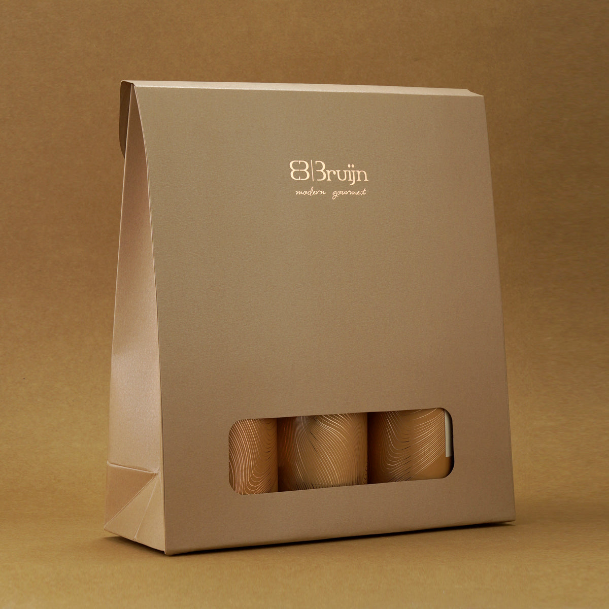 Sustainable beige gift bag with a window showing eco-friendly snack cylinders inside.