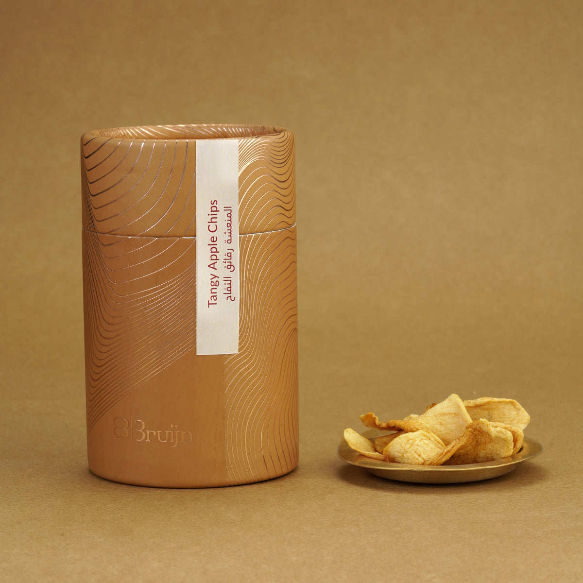 Sustainable cylinder pack of tangy apple chips, flavored with curry powder, light and travel-friendly.