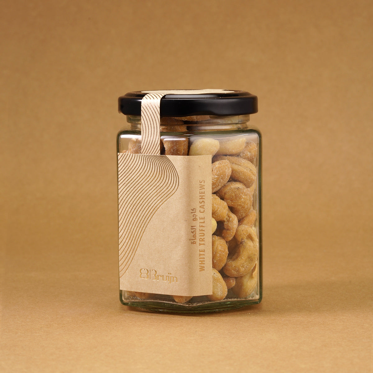 Glass jar of Bruijn Italian White Truffle Cashews with black lid and kraft label, filled with golden cashews coated in aromatic white truffle seasoning.