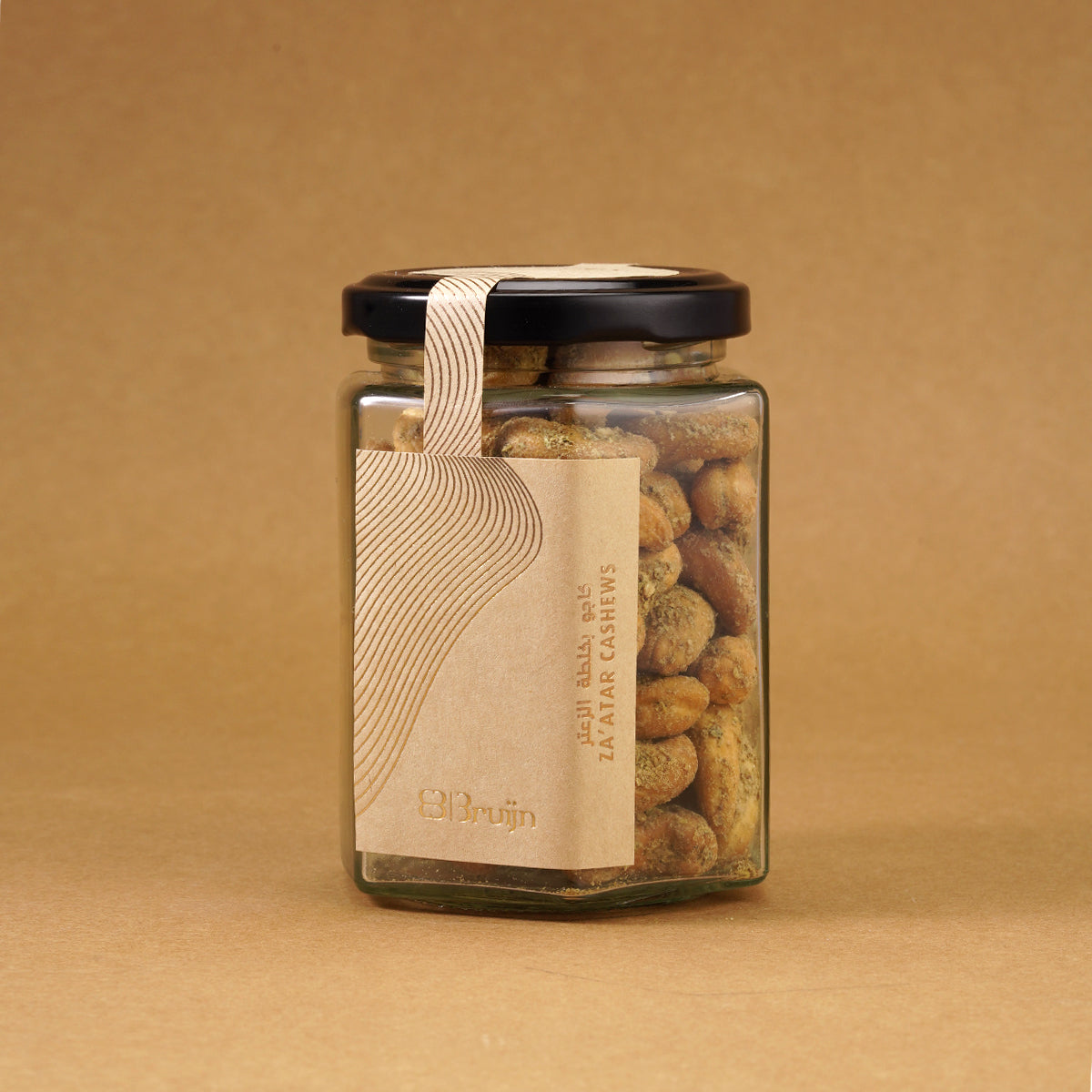 Glass jar of Bruijn Za’atar Cashews with a black lid and kraft paper label, showing spiced cashews inside.