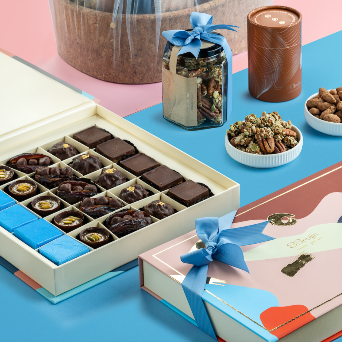 Luxury announcement basket with chocolates, figs, nuts, apple chips, and dates in premium gift packaging