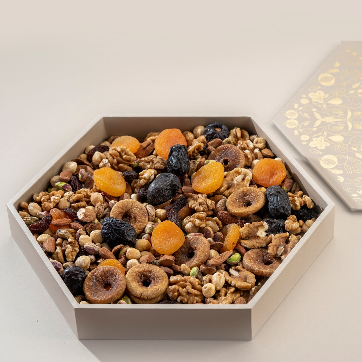 Hexagonal box filled with a mix of dried fruits and nuts on a light background