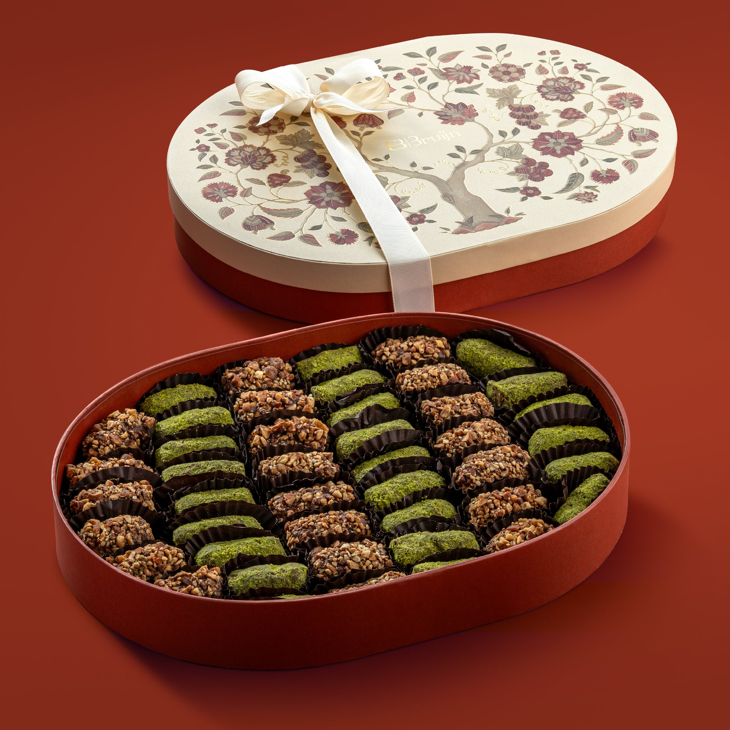 Open box with date truffles encrusted in diced nuts, flavoured with saffron, cardamom and orange blossom water. 