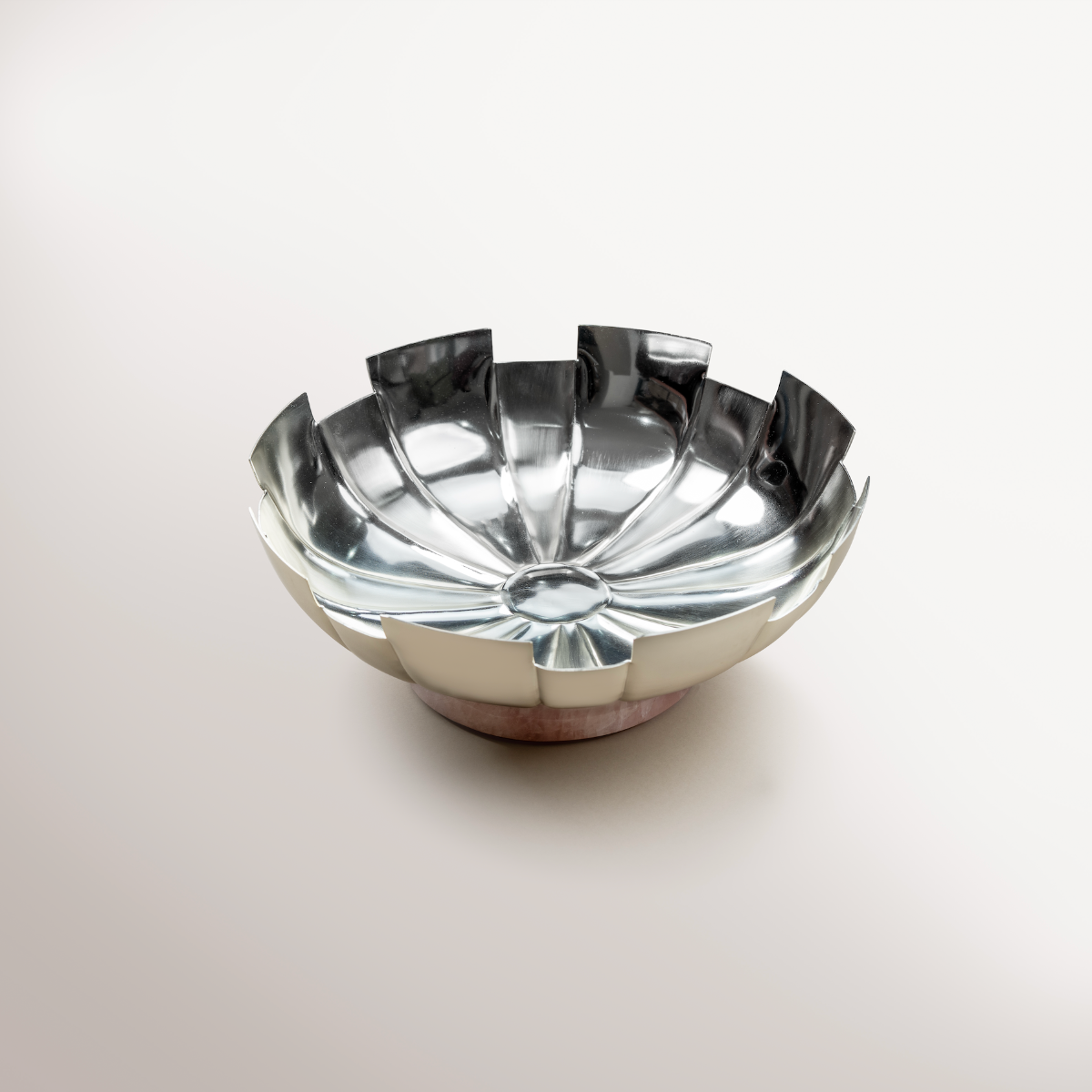 Fluted Silver bowl with Rose Quartz filled with artisanal fig and nut bites alongside pure cacao dark chocolate with nuts, beautifully arranged for gifting.