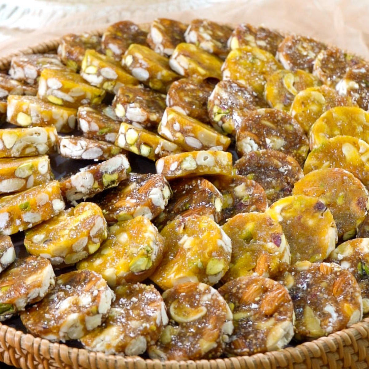 Round tray showcasing roasted nut bites rolled in fig & apricot paste.
