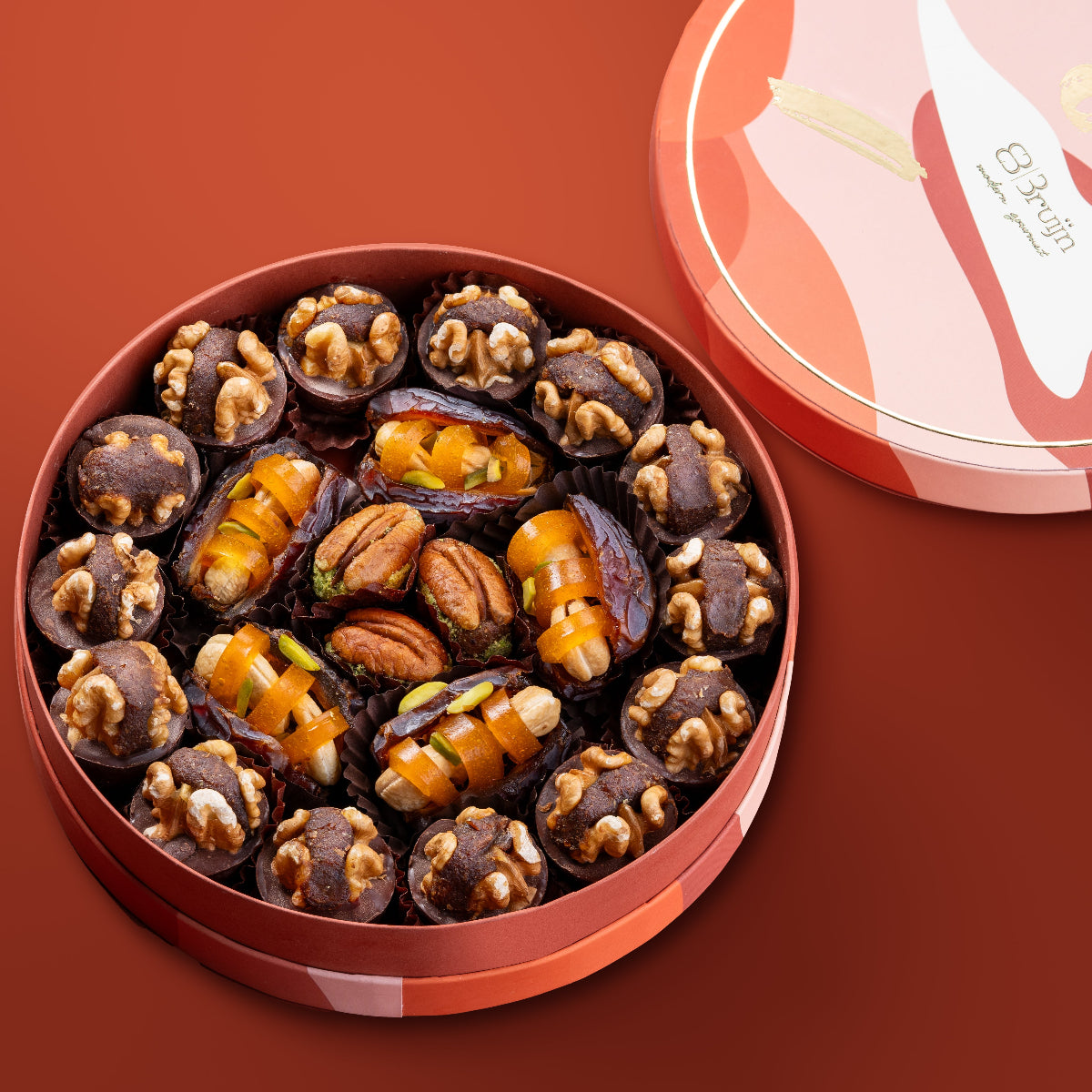 assorted collection holds 600g of chocolate & dried fruit pairing ~ walnut & date wholes in chocolate cups, soft mejdool dates stuffed with dried mango & roasted cashews and pecan & date wholes.