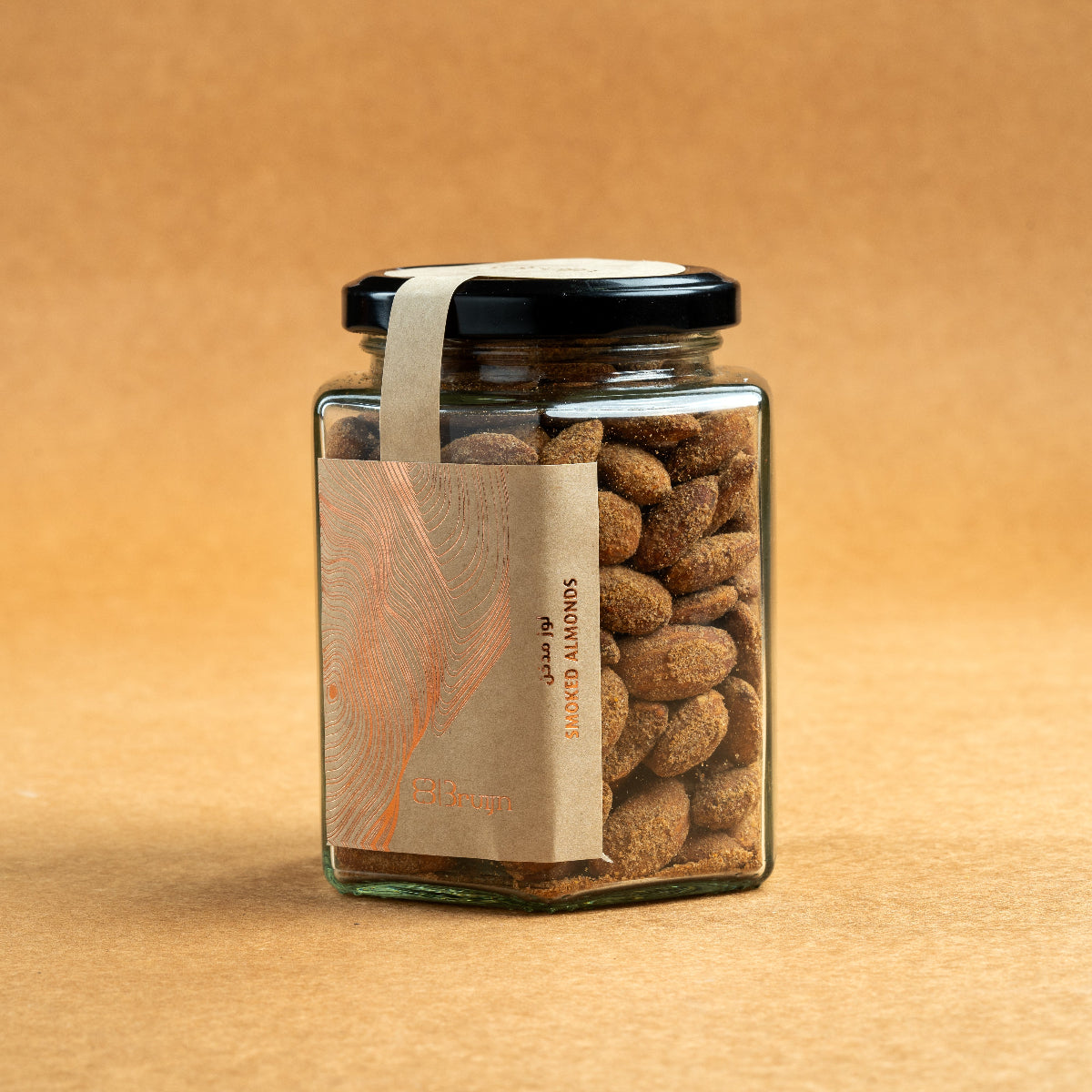 Glass jar of Bruijn Hickory Smoked Almonds with black lid and kraft label, filled with golden almonds infused with smoky hickory flavour.