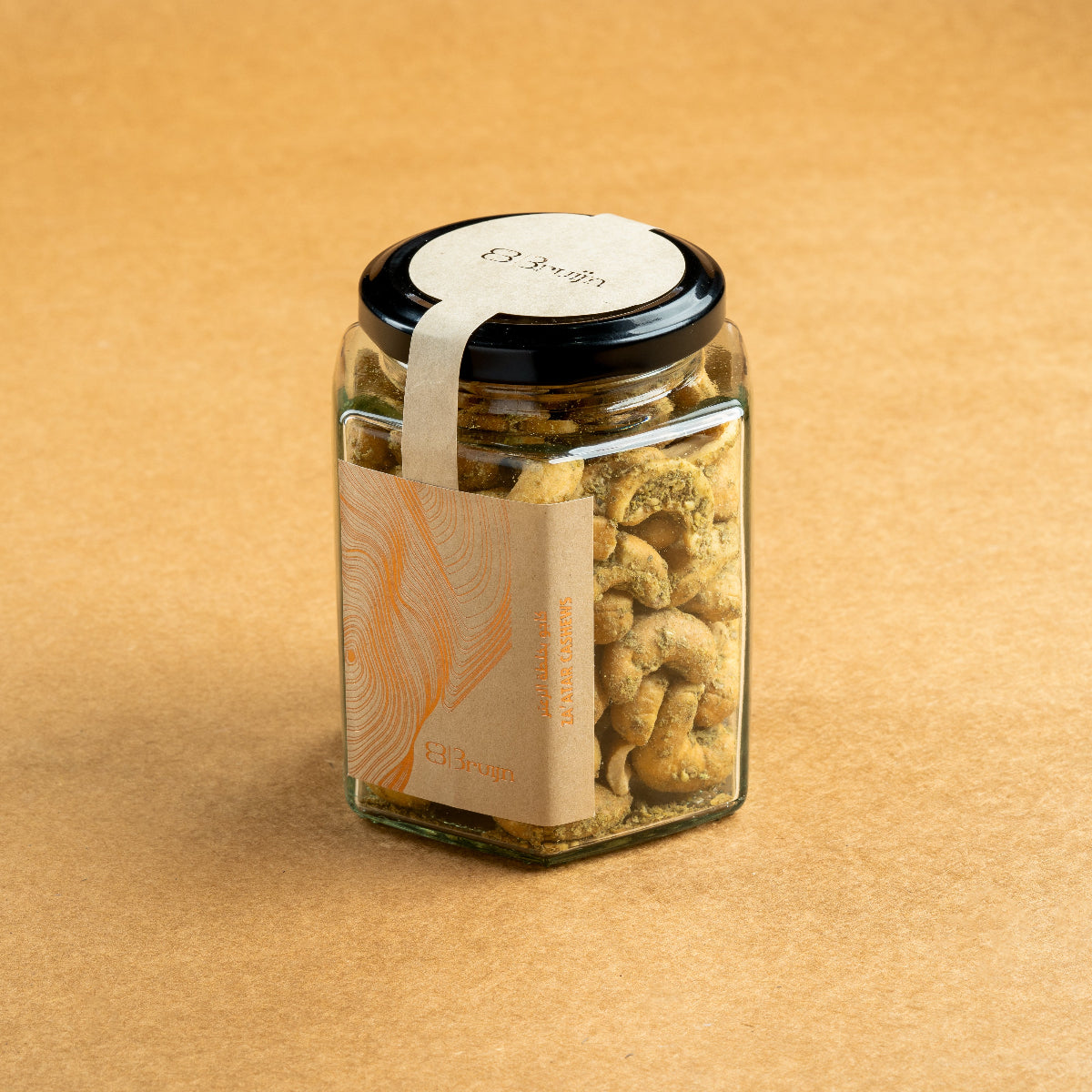 Glass jar of Bruijn Za’atar Cashews with a black lid and kraft paper label, showing spiced cashews inside