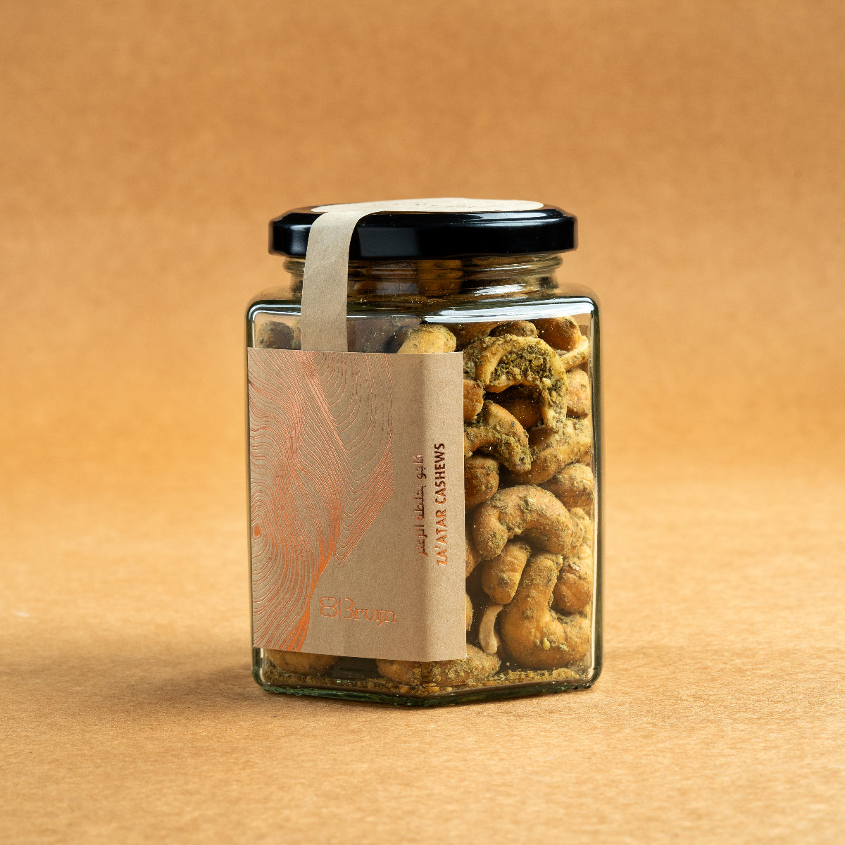 Glass jar of Bruijn Za’atar Cashews with a black lid and kraft paper label, showing spiced cashews inside