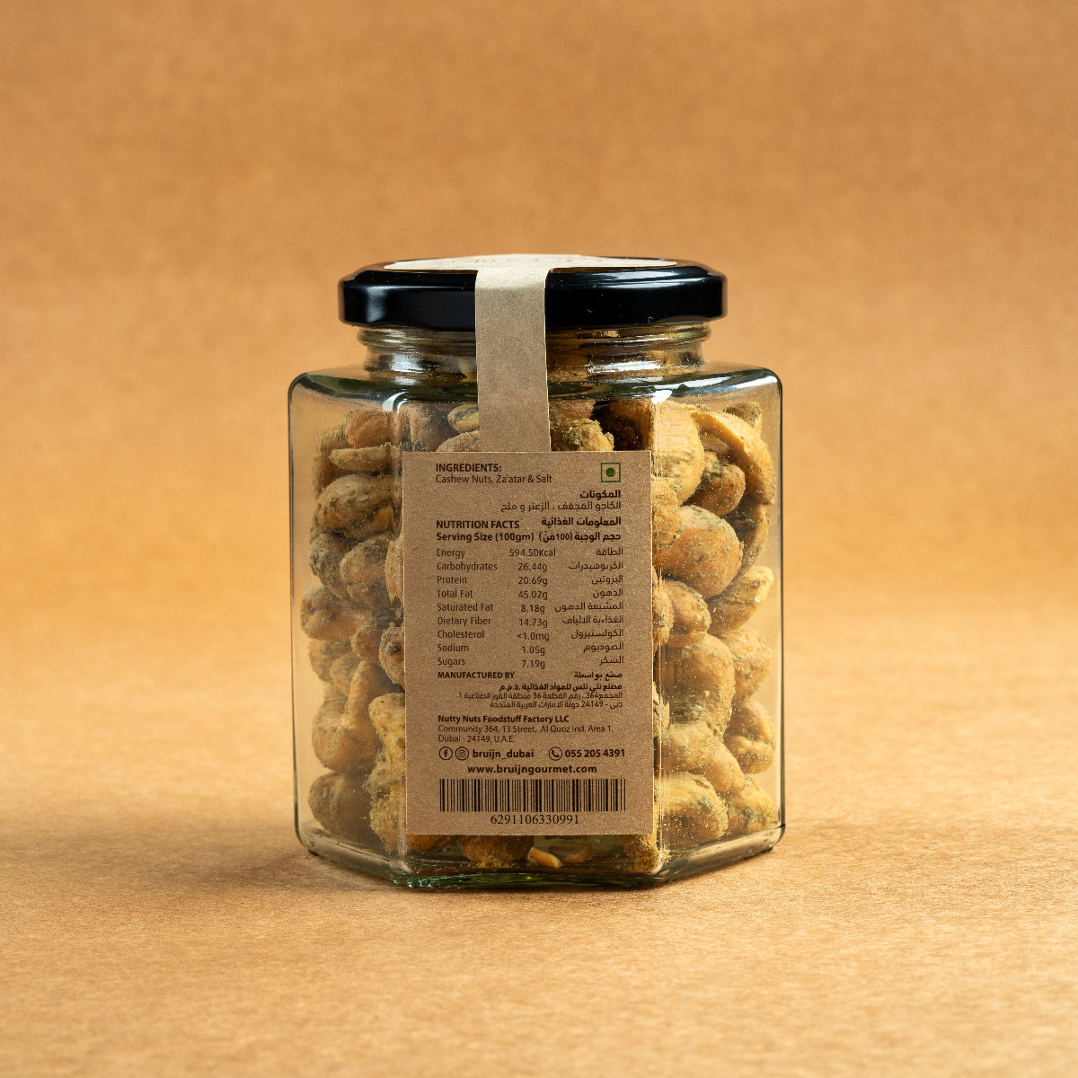 Glass jar of Bruijn Za’atar Cashews with a black lid and kraft paper label, showing spiced cashews inside
