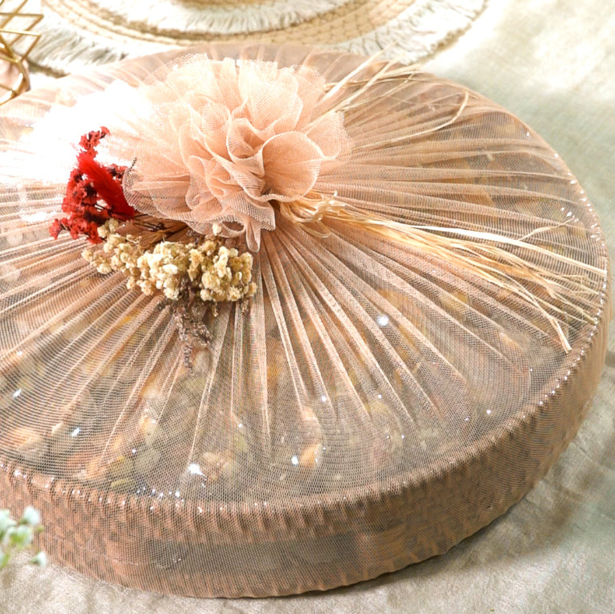 Eco-friendly round tray wrapped in festive net, filled with fig-apricot nut delights.