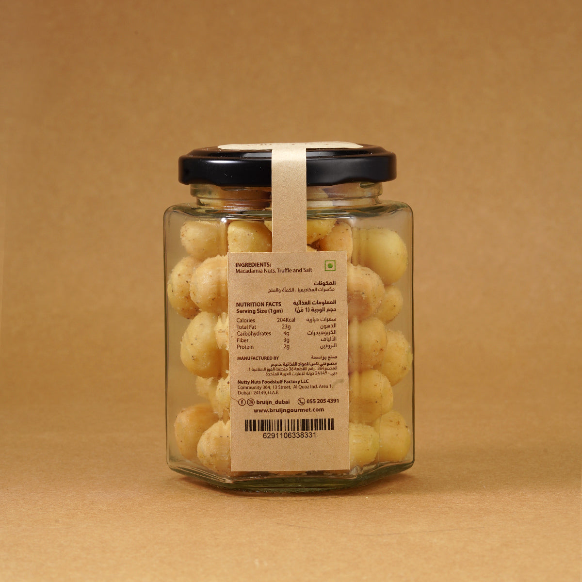 Glass jar of Bruijn Italian Black Truffle Macadamias with black lid and kraft label, filled with golden macadamia nuts coated in aromatic truffle seasoning.
