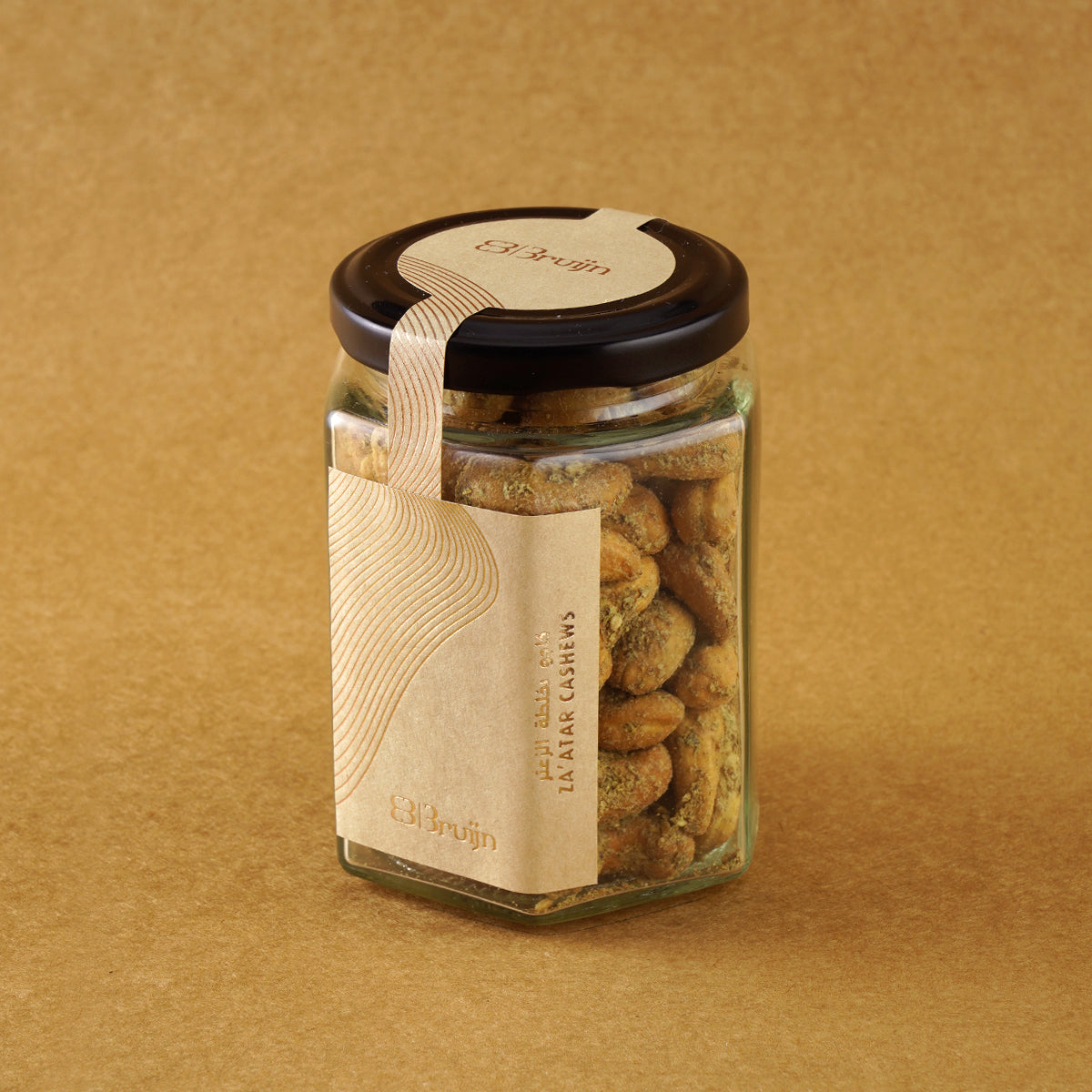 Glass jar of Bruijn Za’atar Cashews with a black lid and kraft paper label, showing spiced cashews inside.